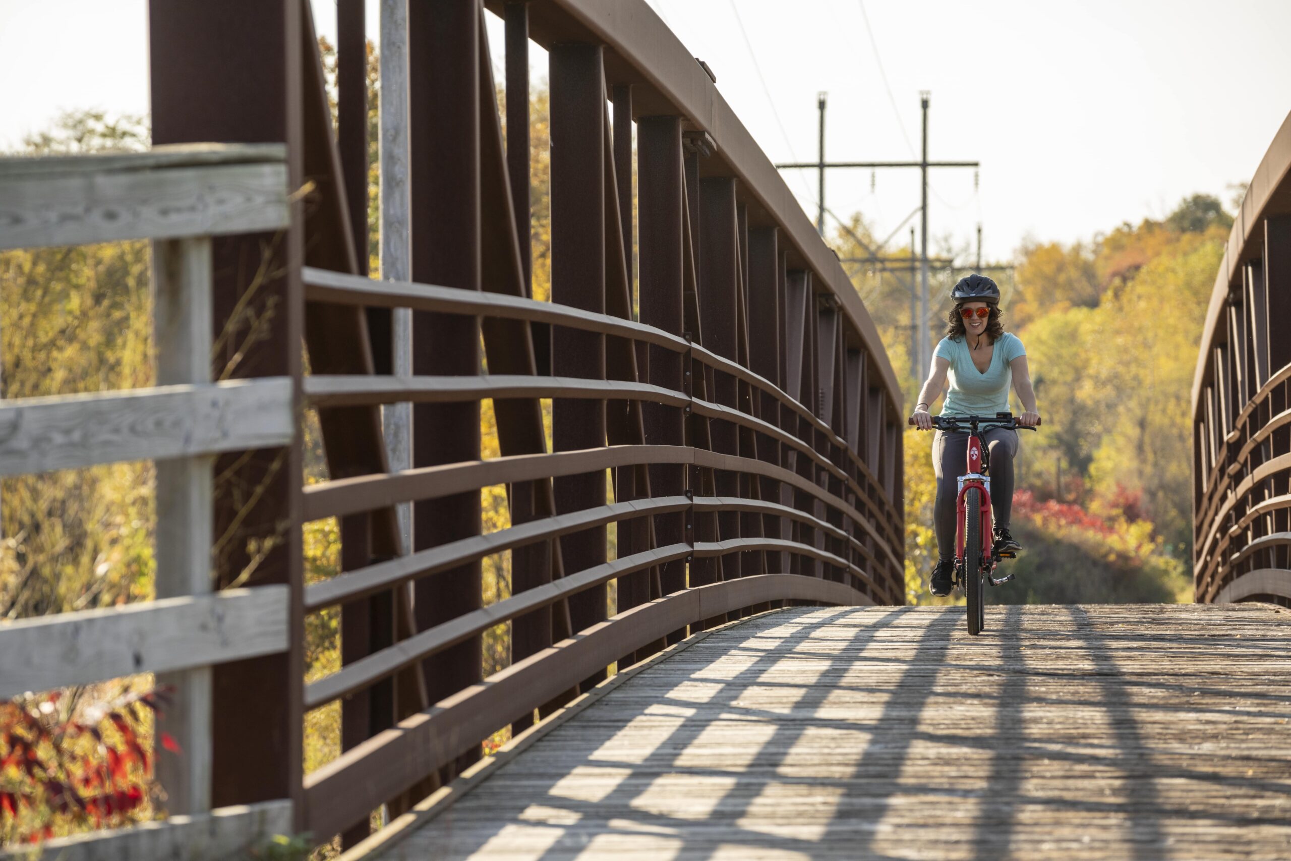 woman riding ebike across bridge