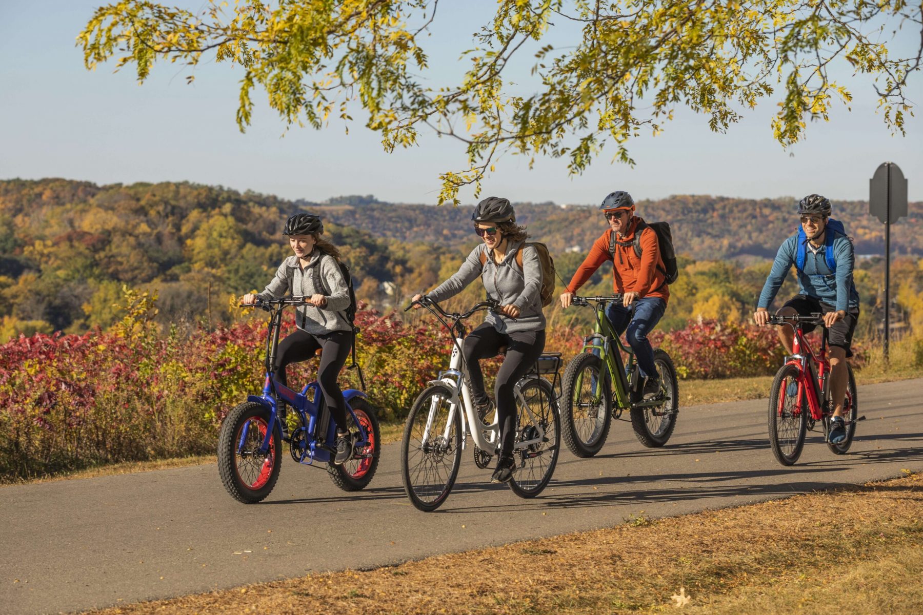 group of four people riding ebikes on bike trail