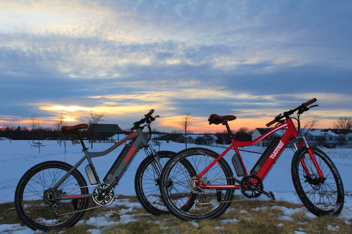 two bikes in front of snow and sunset